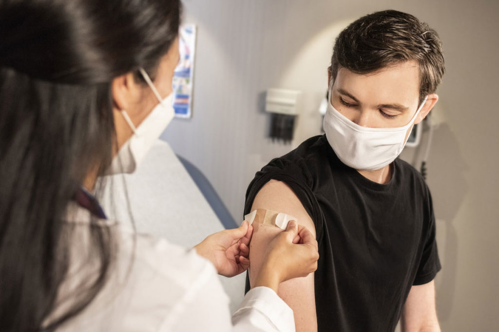 nurse applying bandaid after vaccine